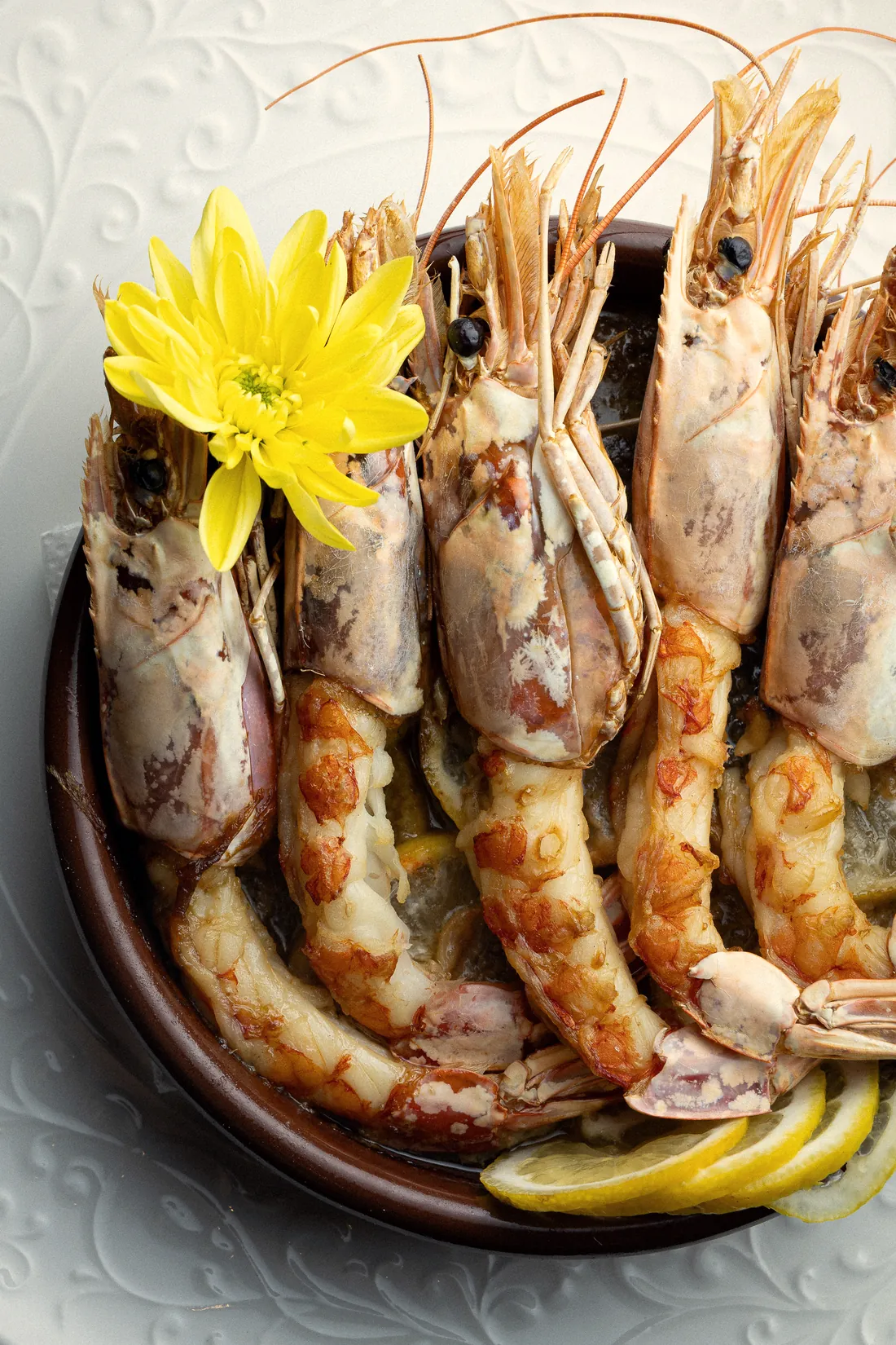 Gamberoni in tegamino con limone e fiore giallo