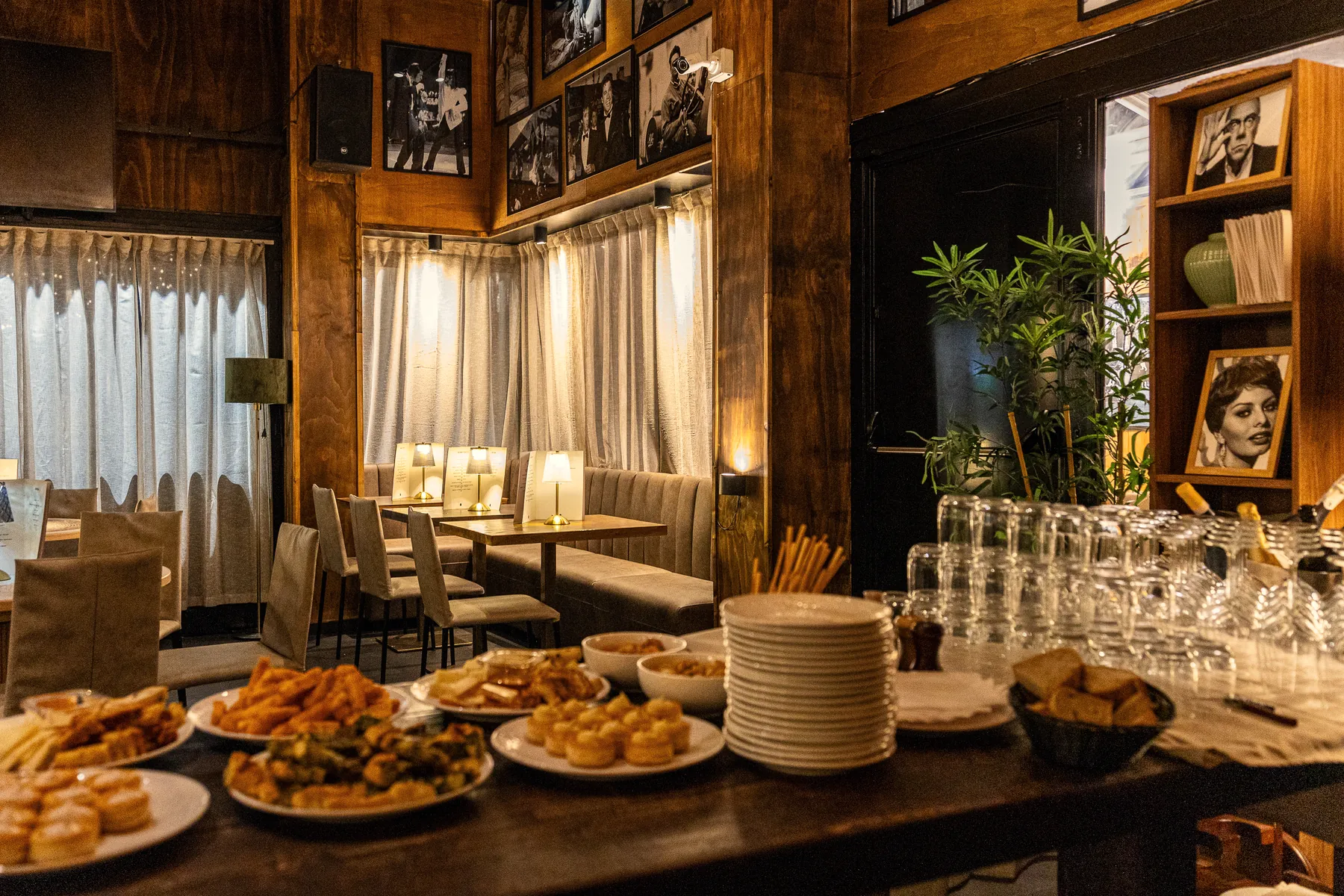 Il buffet di piatti e bicchieri davanti alle tende della sala